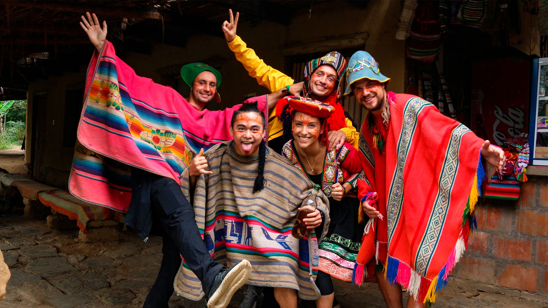 Group of tourists wearing colorful ponchos and smiling at a local coffee farms | Conde Travel Adventures