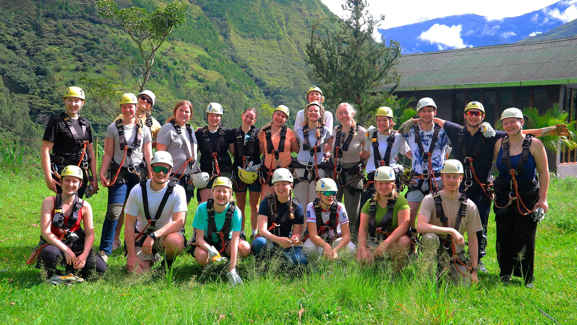 Grupo de turistas con cascos y arneses listos para zipline en el tour Inca Jungle en Cusco, rodeados de montañas verdes y naturaleza | Conde Travel Adventures