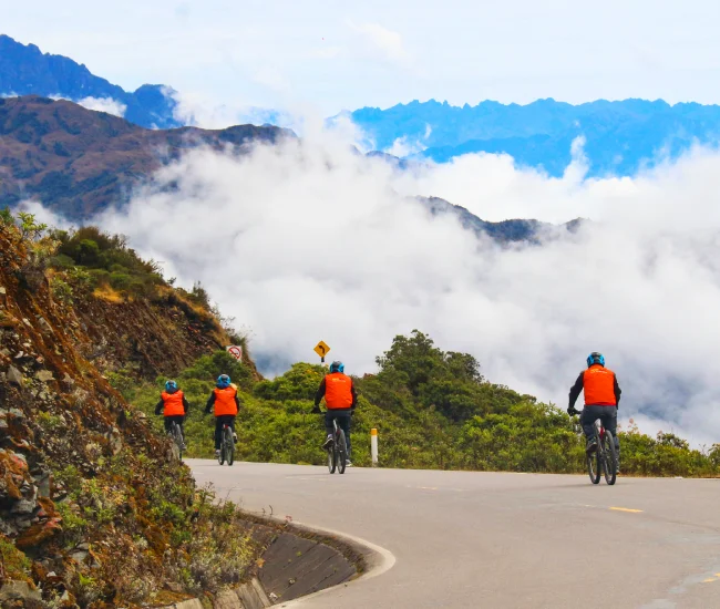 Adventure cyclist descending a winding road in the Andes on the Inca Jungle tour to Machu Picchu | Conde Travel Adventures