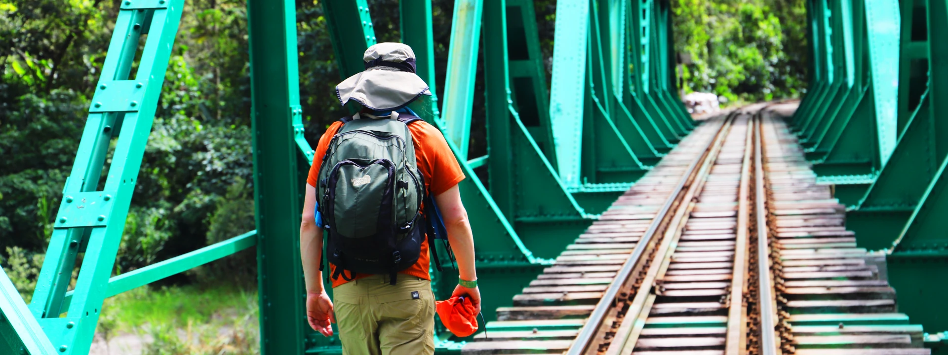 Tourist walking across a railway bridge near the Hydroelectric Station on the route to Machu Picchu | Conde Travel Adventures