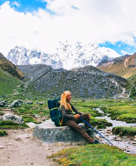 Woman hiking the Salkantay Trek in Peru, surrounded by snow-capped mountains and scenic Andean landscapes