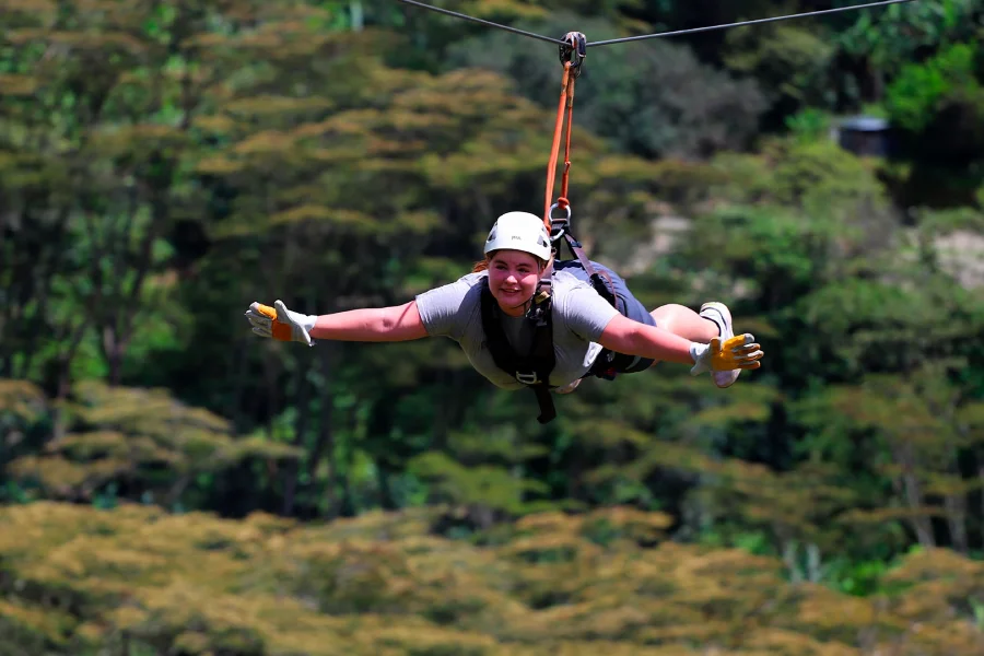 Traveler ziplining over lush landscapes on the Inca Jungle route in Cusco | Conde Travel Adventures