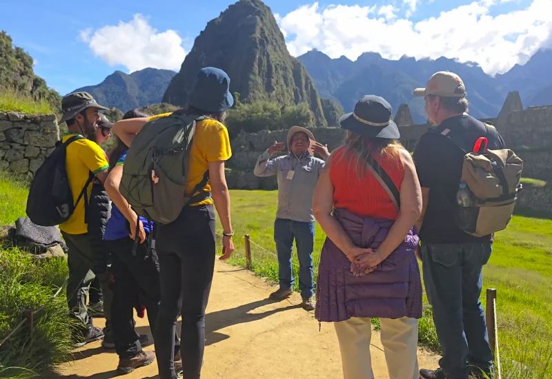 Private guide explaining the history of Machu Picchu to travelers.