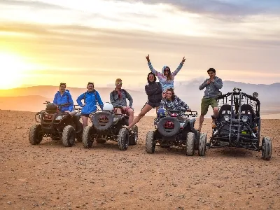 Tourists riding ATVs and dune buggies in the desert of Ica, Peru at sunset | Conde Travel Adventures